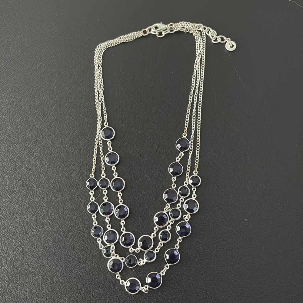 Silver necklace with 3 rows of navy blue gems on each side.